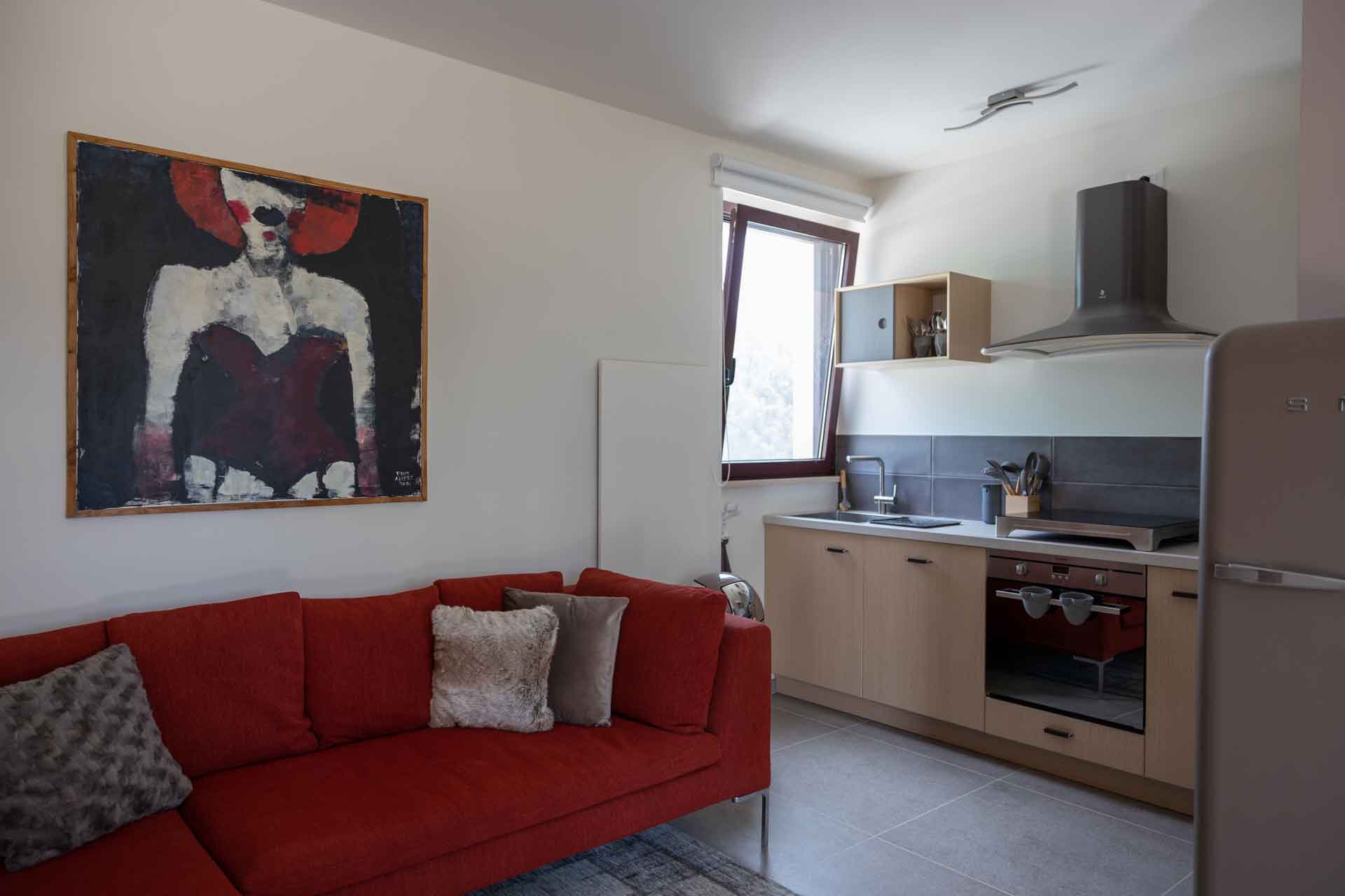 Couch and kitchen in Apartment Gualdo at Colpo di Fortuna